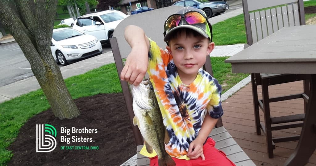 Boy holding fish he caught