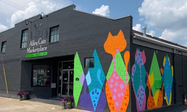 Exterior of Alley Cats Marketplace featuring bright cat mural